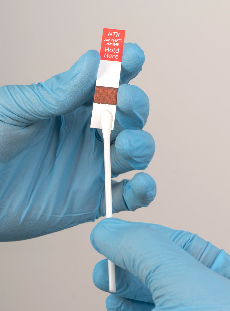 swabtek amphetamine detection test in use by gloved hands